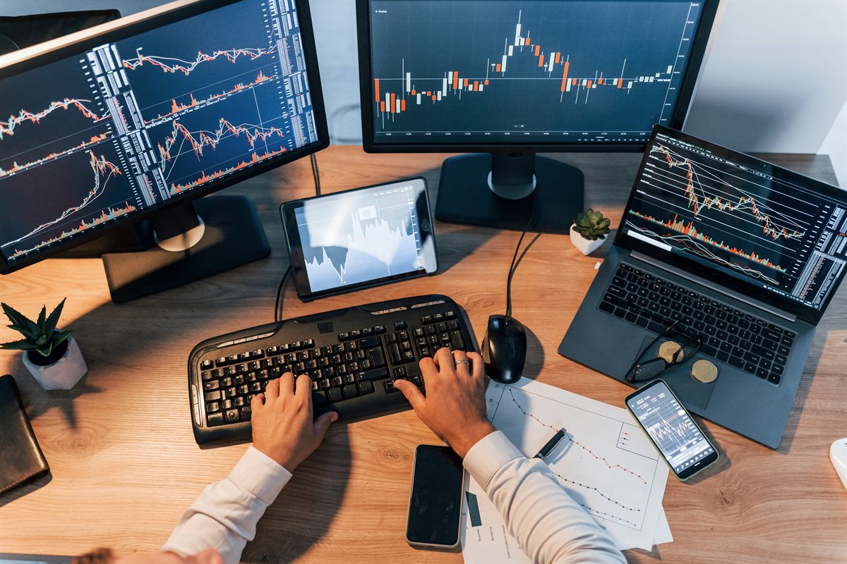 Profesional trabajando con datos centralizados en varias pantallas desde su puesto